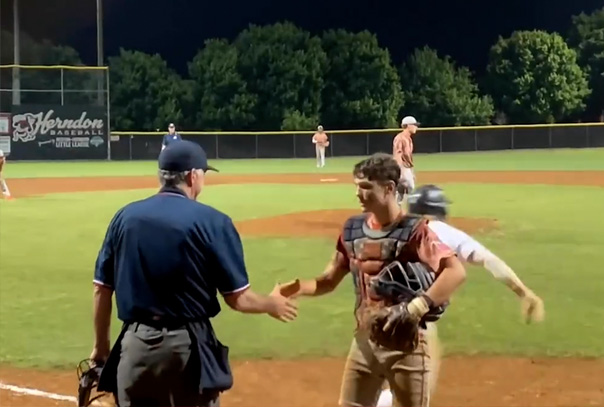 A catcher shaking an umpires hand at home plate