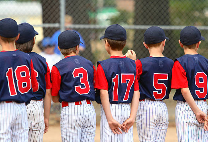 Youth Baseball team facing away from camera with each player's jersey number showing