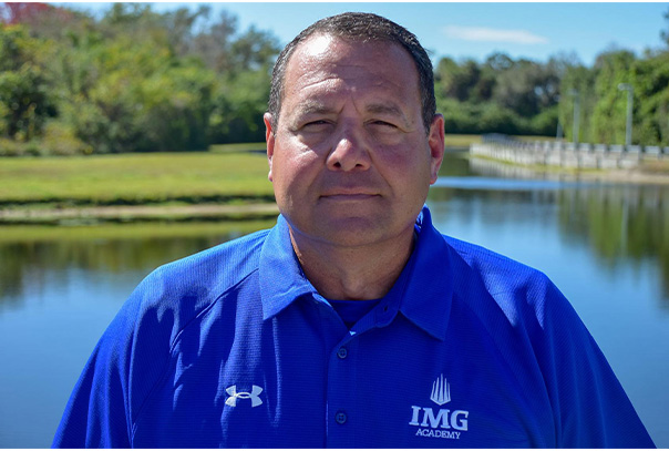Joe Jordano headshot in blue IMG Academy polo shirt