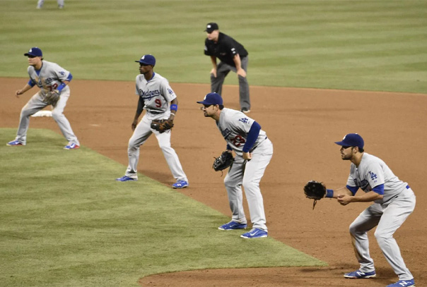 Four Los Angeles Dodgers infielders waiting for ball between first and second base
