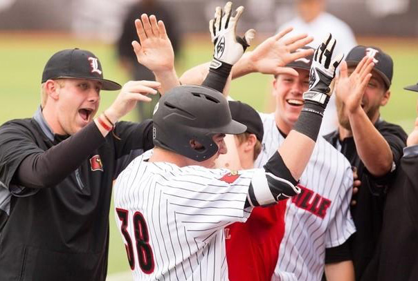 Louisville #38 high fives a group of smiling teammates