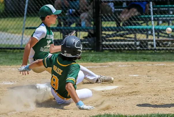Pitcher covering home on a passed by while runner is sliding into home.