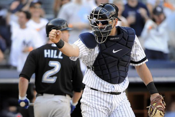 A Yankees catcher fist pumping in an encouraging manner
