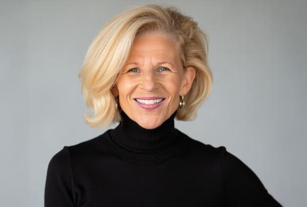Sue Enquist headshot in front of grey background