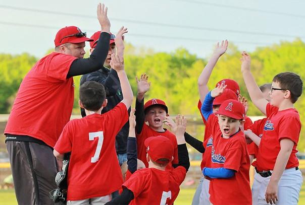Youth team high fiving with each other and coaches