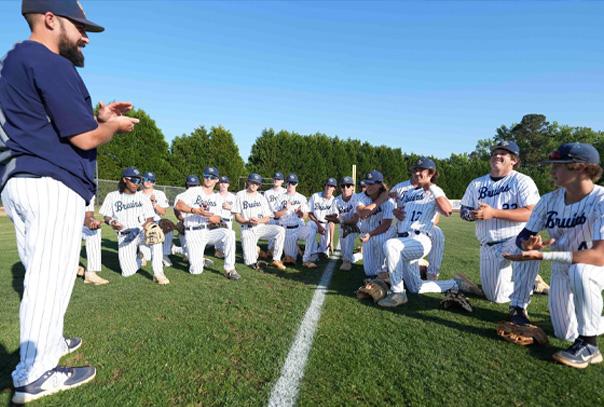 Coach Hyman, the author, speaking to team on field huddled around him.